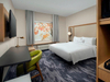 Fairfield Inn &amp; Suites com mesa de cabeceira king size e móveis de hotel